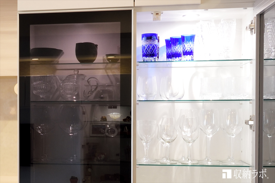 オーダーメイドの食器棚の扉には、スモークガラスを採用。照明の点灯中のイメージ。